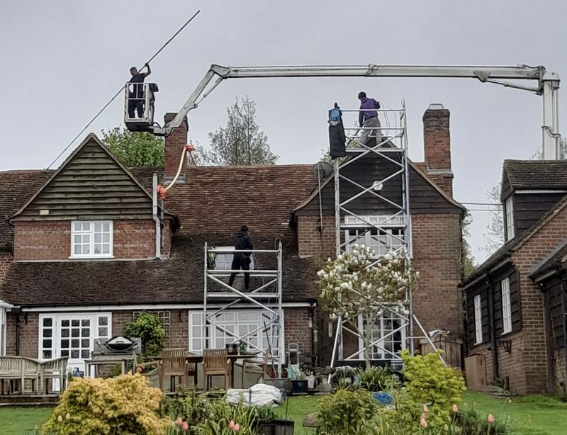 The Moss Cleaners using cherry picker and scaffolding to clean roof safely and professionally in Trowbridge, Wiltshire